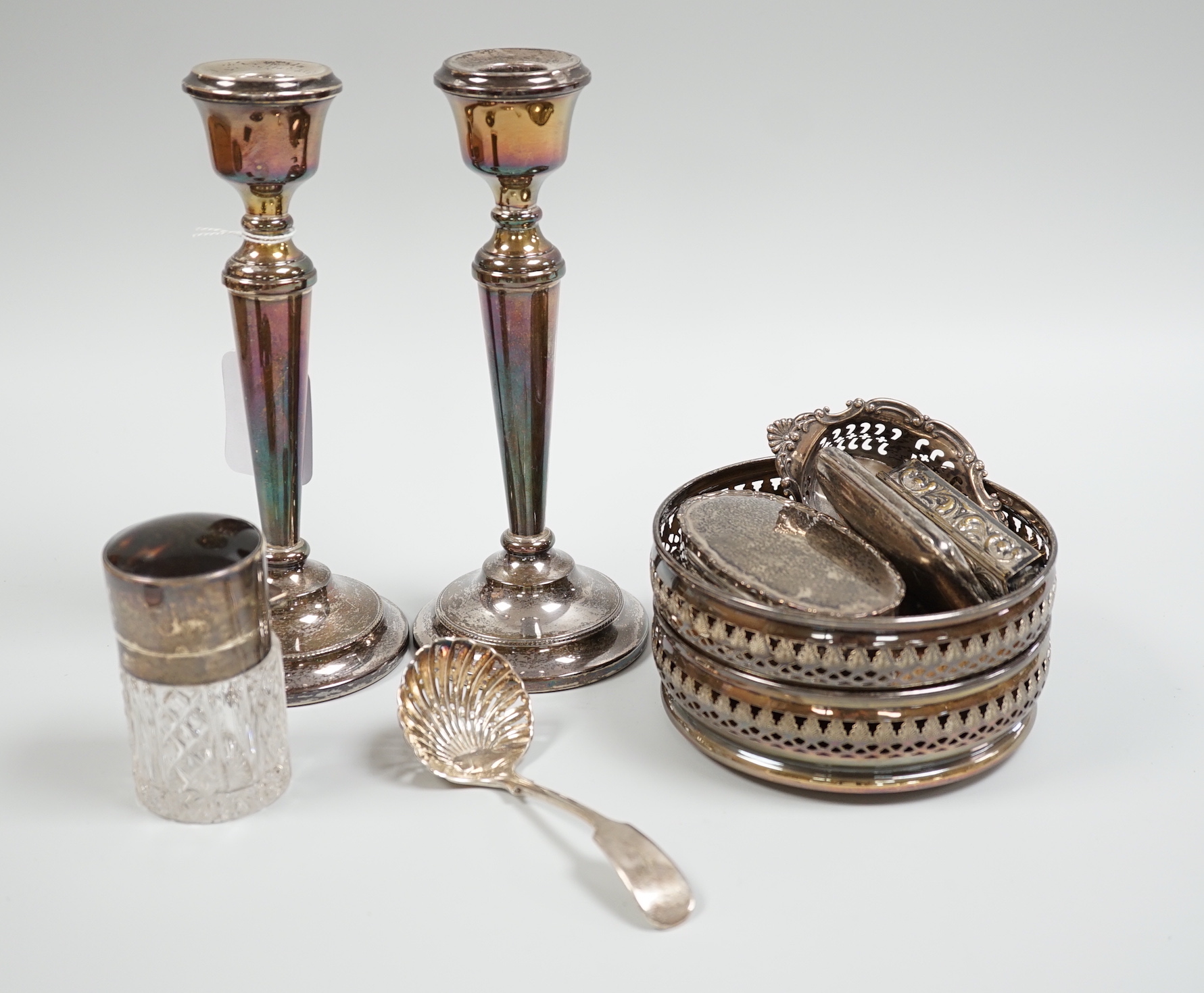 A pair of 1960's pierced silver wine coasters, London, 1968, diameter 13.2cm, a modern pair of silver candlesticks, a silver and tortoiseshell mounted glass salts bottle, a silver trinket box, sterling pierced dish, silv